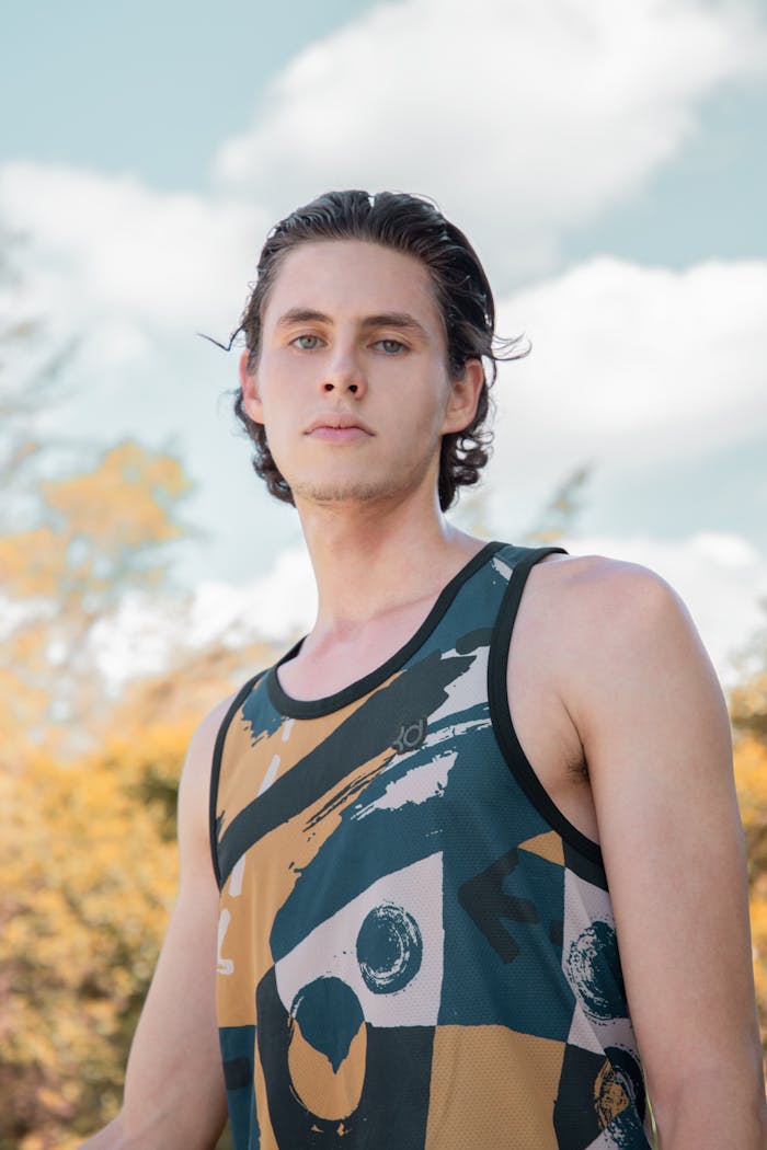 Portrait of a young man standing outdoors in Mexico City wearing a unique graphic tank top.